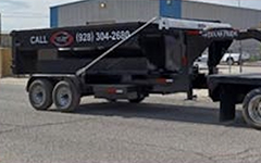 13-Yard Roll-Off Dumpster attached to company truck used for rental and delivery of residential trash.